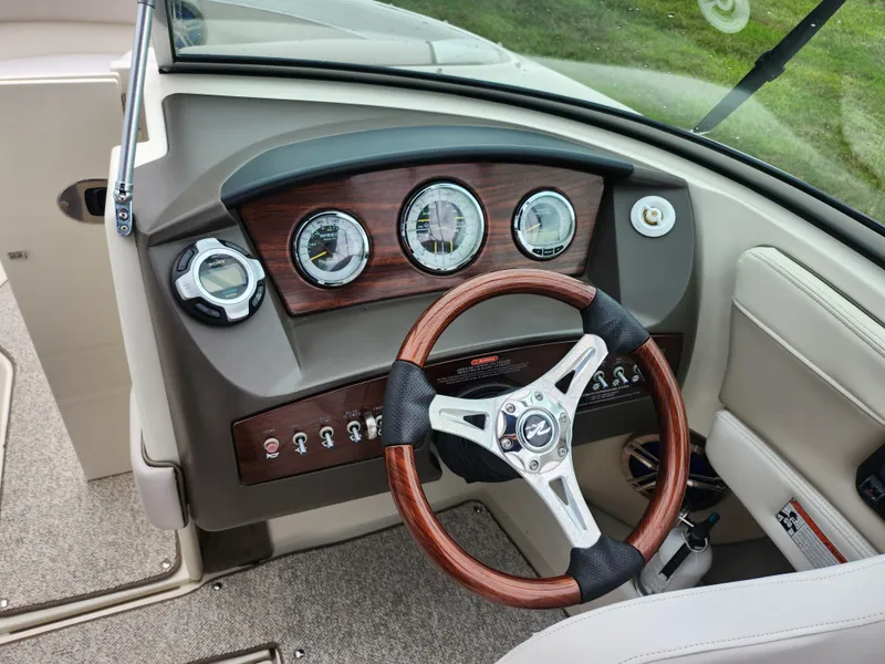 Slide: The Image of Dashboard of 2010 Sea Ray 210 Select boat with wood accents and steering wheel. - 14