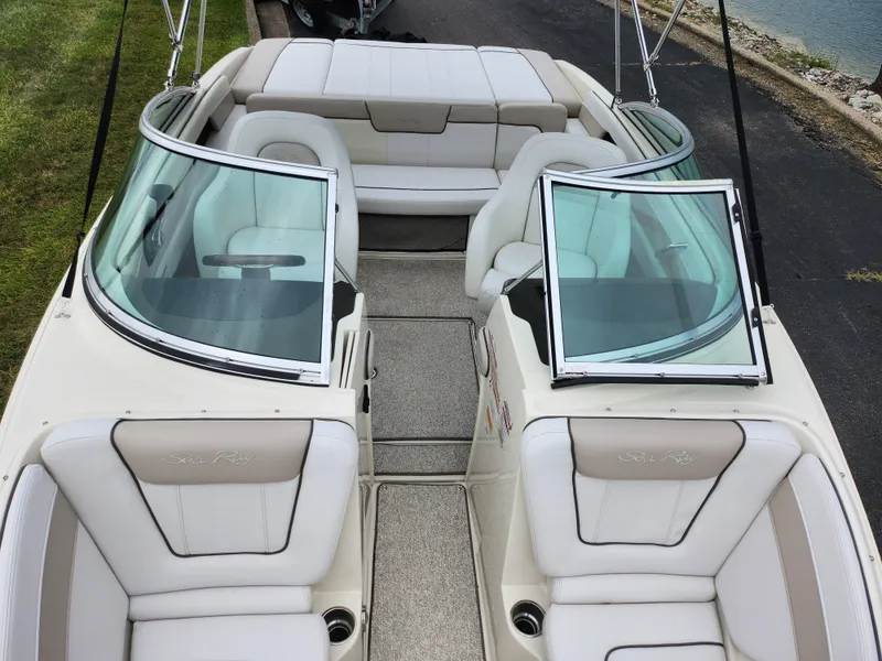 Slide: The Image of 2010 Sea Ray 210 Select boat interior with white seating and open windshield. - 20