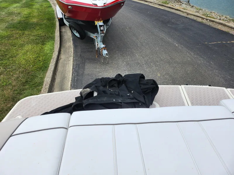 Slide: The Image of Sea Ray 210 Select boat interior with jacket, trailer in background. - 27