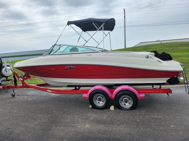 Slide: The Image of 2010 Sea Ray 210 Select boat on a red trailer, parked outdoors. - 4