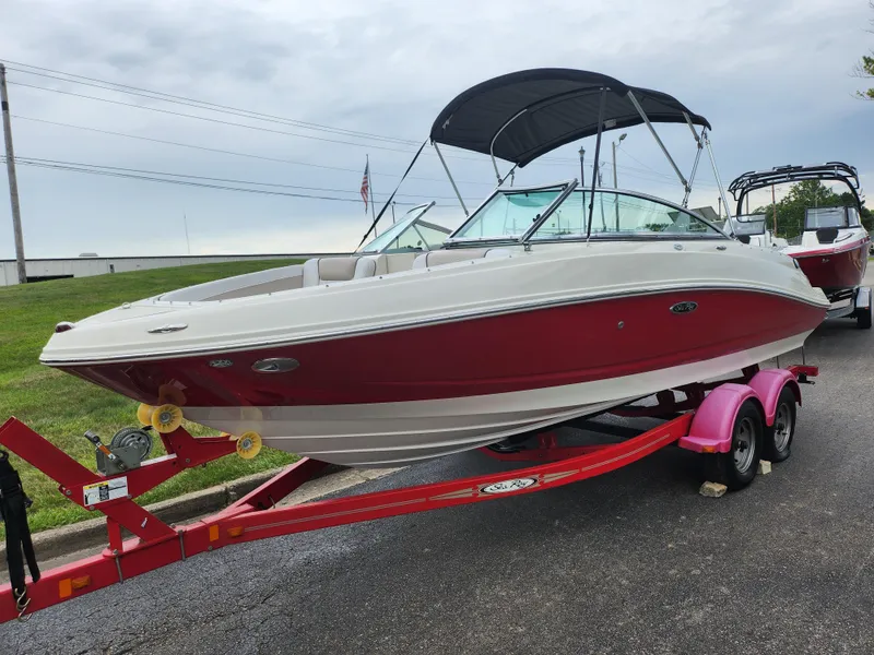 Slide: The Image of 2010 Sea Ray 210 Select boat on a red trailer, parked outdoors. - 5