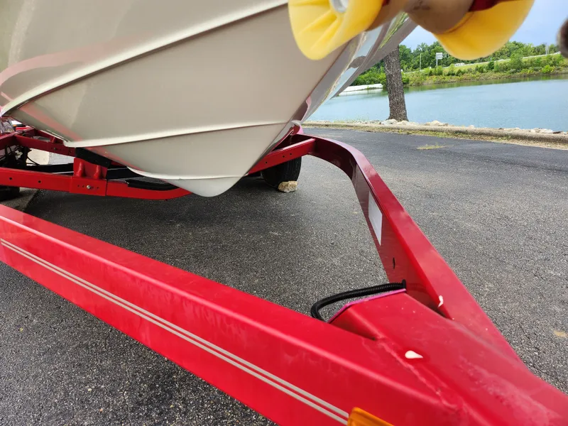 Slide: The Image of Red trailer with 2010 Sea Ray 210 Select boat near a lake. - 7