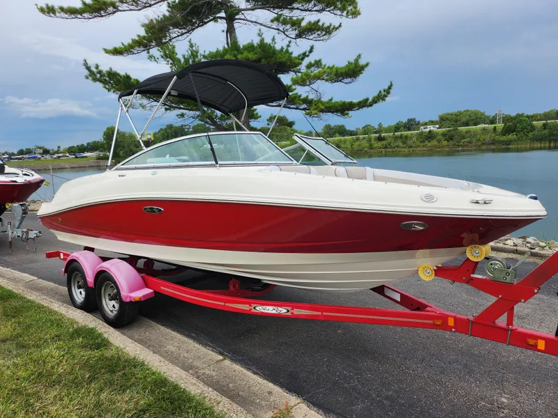 Slide: The Image of 2010 Sea Ray 210 Select boat on a red trailer by a lake. - 8