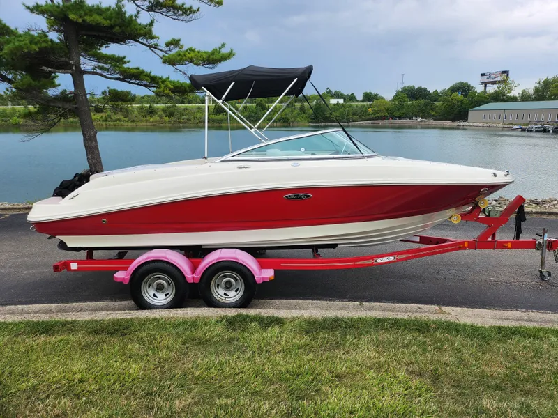 Slide: The Image of 2010 Sea Ray 210 Select boat on red trailer by a lake. - 9
