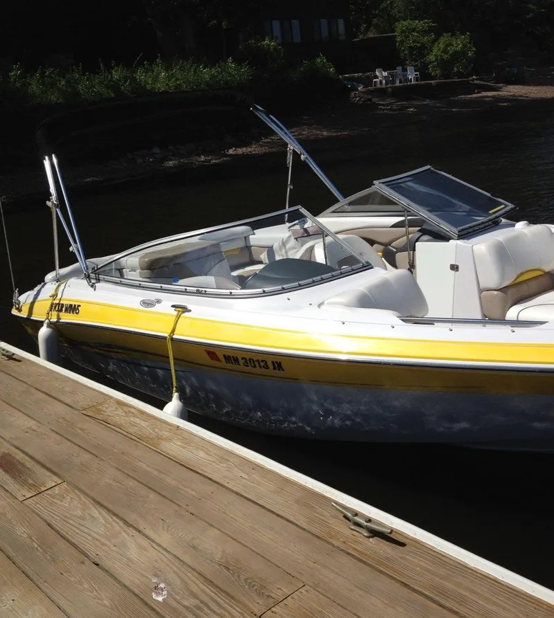 Slide: The Image of 2005 Four Winns 200 Horizon LE boat docked, featuring yellow and white design. - 2