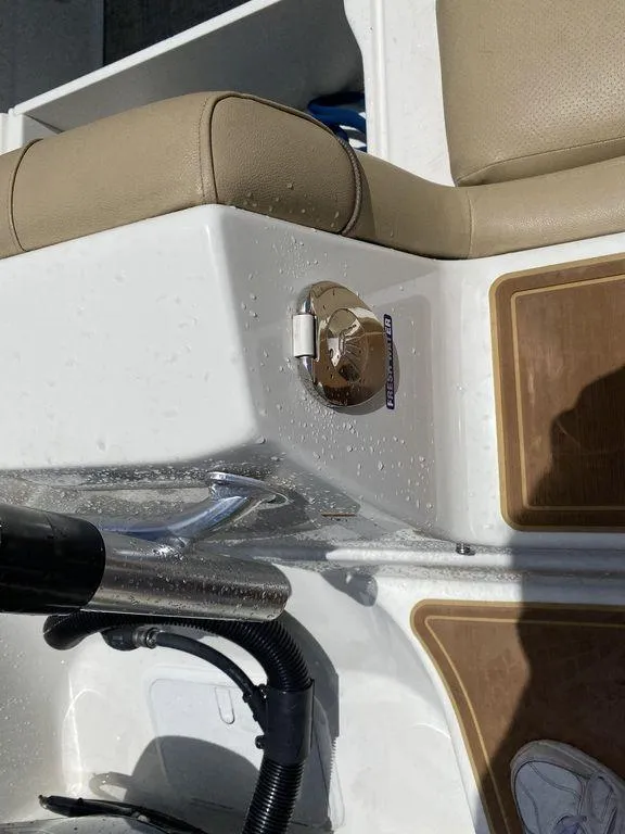Slide: The Image of 2019 NauticStar 243 DC boat interior with beige seating and chrome details. - 10