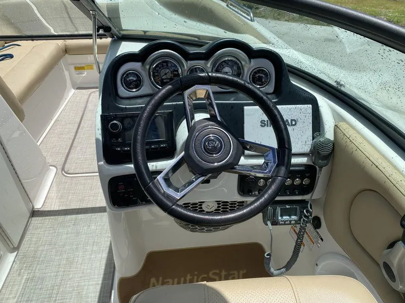 Slide: The Image of 2019 NauticStar 243 DC boat dashboard with steering wheel and navigation controls. - 14