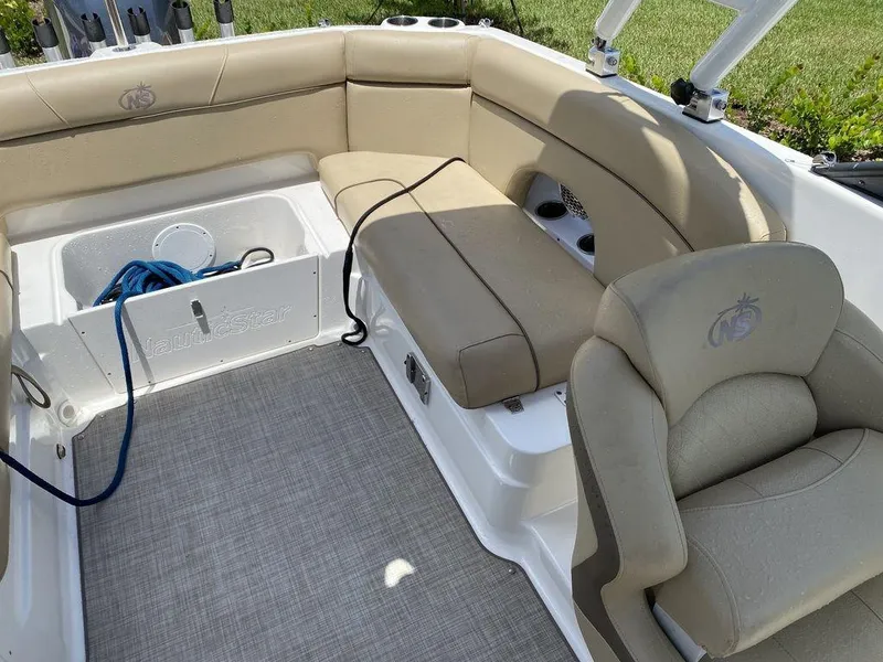 Slide: The Image of 2019 NauticStar 243 DC boat interior with beige seating and storage compartment. - 2