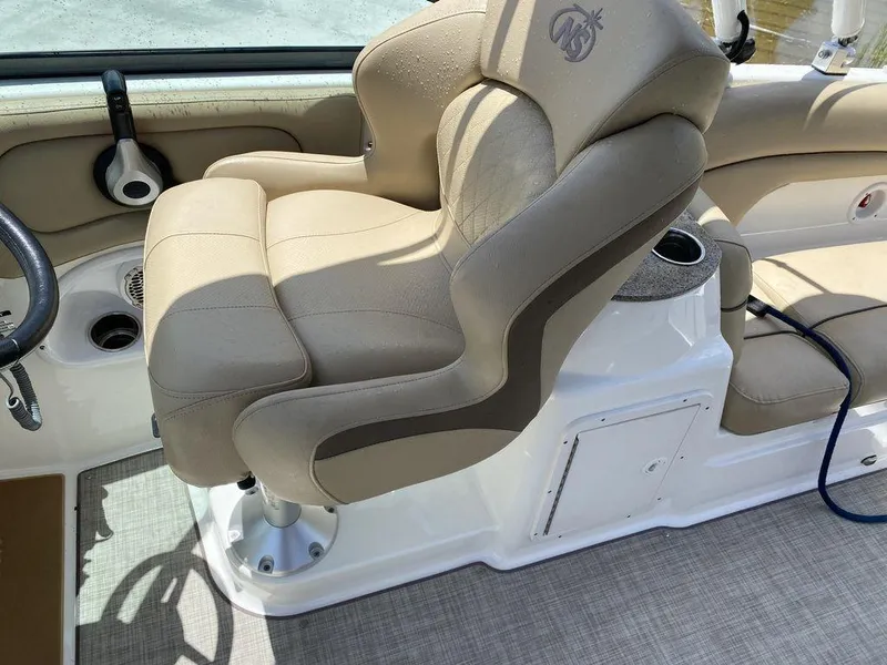 Slide: The Image of 2019 NauticStar 243 DC boat interior with beige captain's chair and console. - 3