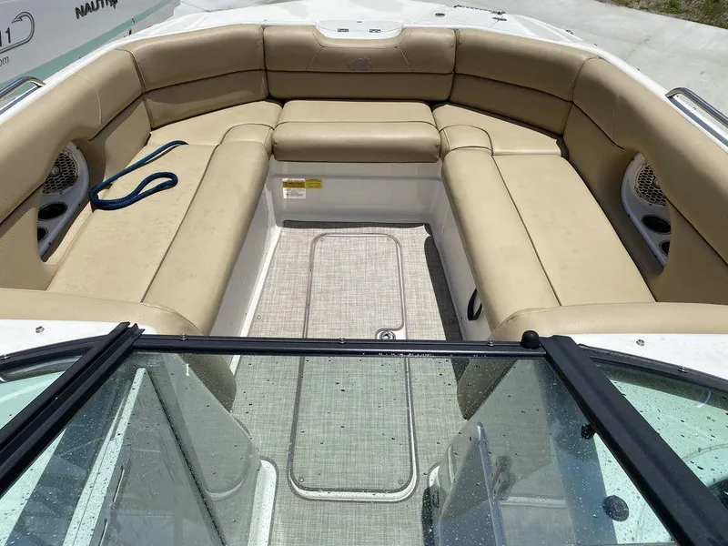 Slide: The Image of 2019 NauticStar 243 DC boat interior with beige seating and open deck. - 4