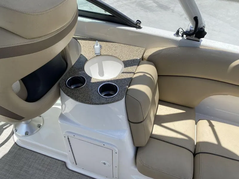 Slide: The Image of 2019 NauticStar 243 DC boat interior with beige seating and cup holders. - 5