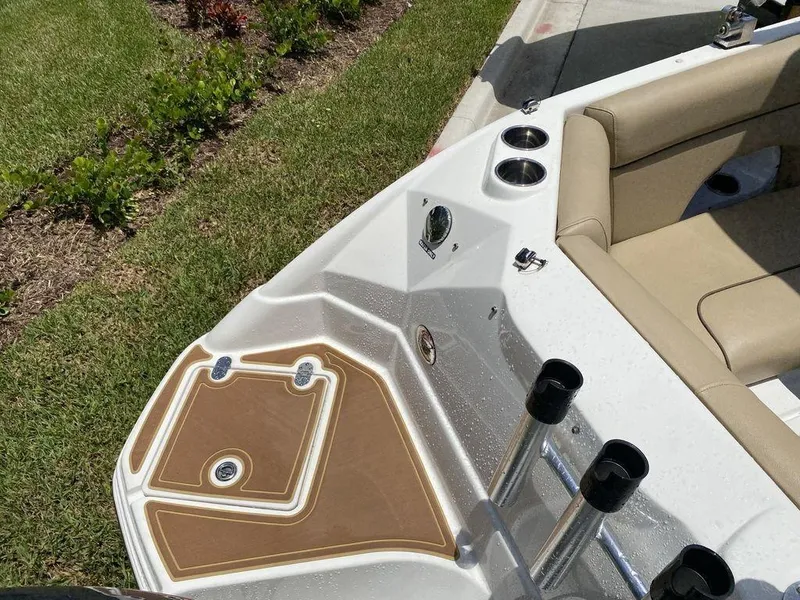 Slide: The Image of 2019 NauticStar 243 DC boat interior with tan seating and cup holders. - 8
