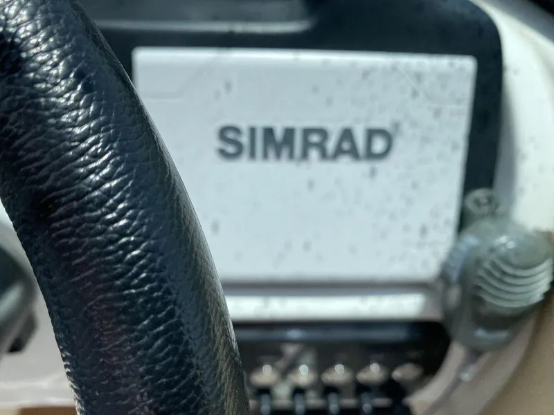 Slide: The Image of Close-up of a 2019 NauticStar 243 DC dashboard with Simrad navigation system. - 9