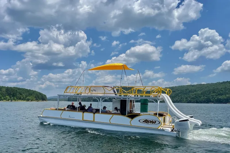 The Image of Aloha Pontoon 40' Sky View 2025 cruising on a lake under a partly cloudy sky. - 0