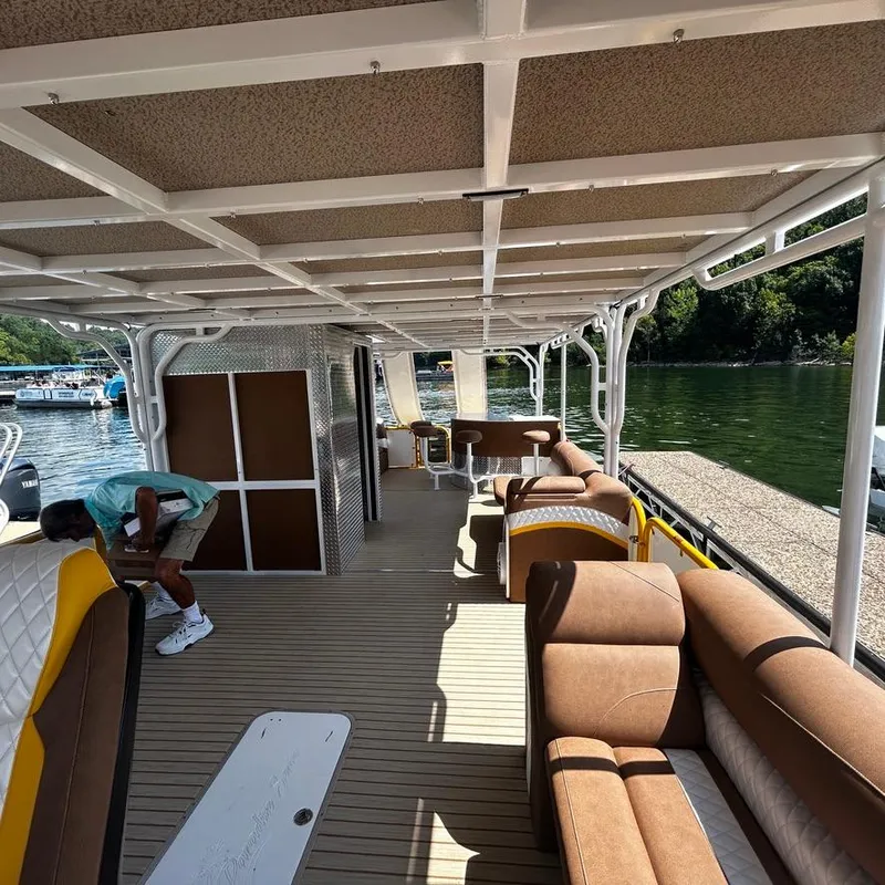 Slide: The Image of 2025 Aloha Pontoon 40' Sky View interior with brown seating, spacious deck, and lake view. - 10