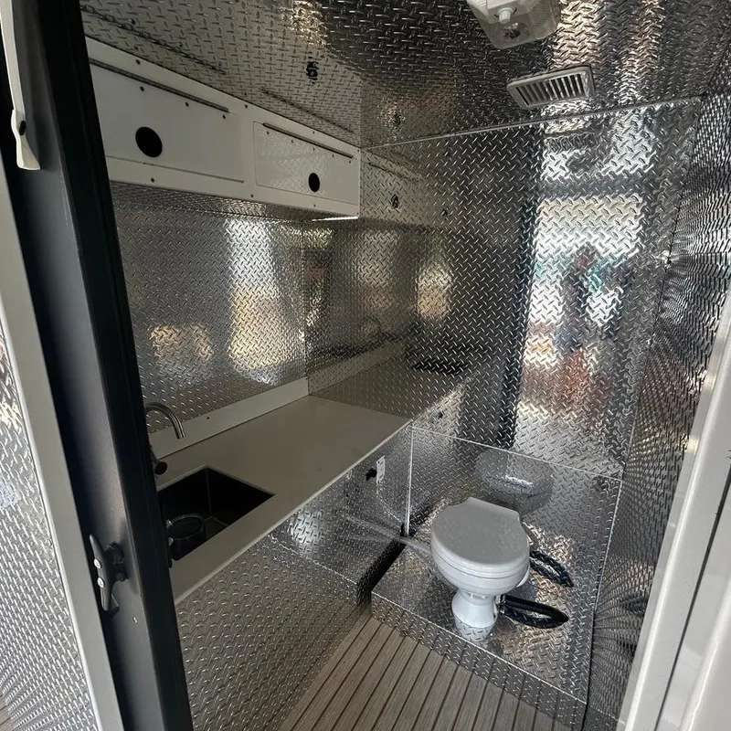 Slide: The Image of Interior of 2025 Aloha Pontoon 40' Sky View with metallic finish and compact bathroom. - 12