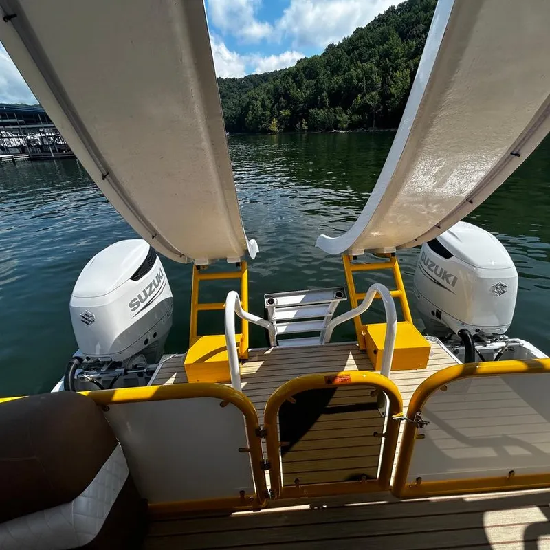 Slide: The Image of 2025 Aloha Pontoon 40' Sky View with dual Suzuki engines and water slides on a lake. - 14