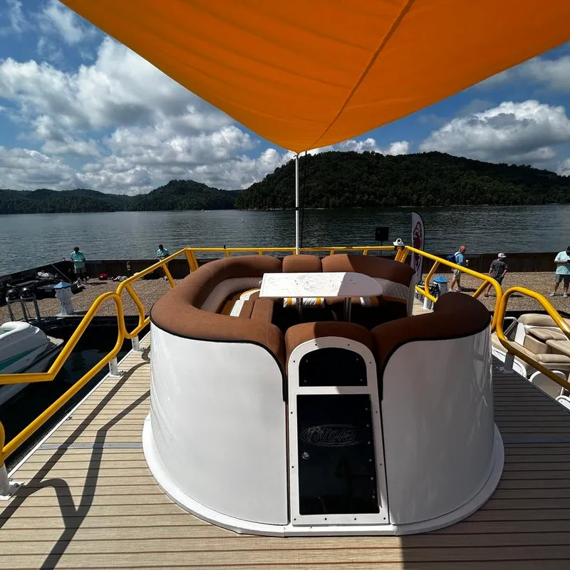 Slide: The Image of Aloha Pontoon 40' Sky View 2025 on a scenic lake with seating and canopy. - 15