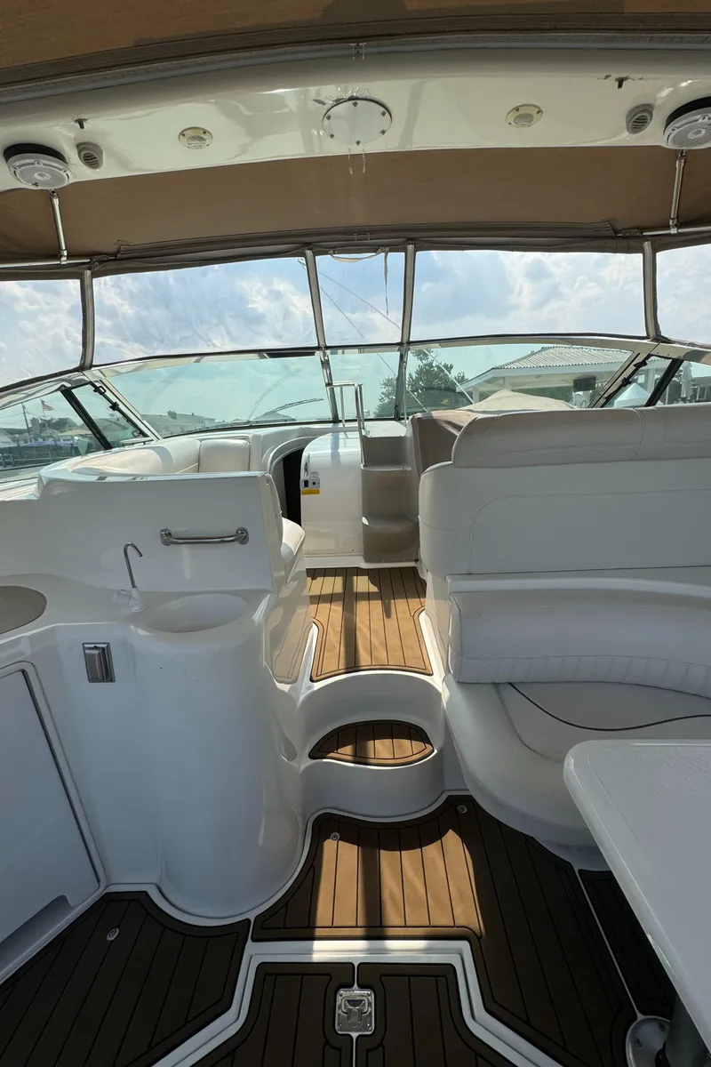 Slide: The Image of 2001 Cruisers Yachts 3870 Express interior with white seating and wood flooring. - 4