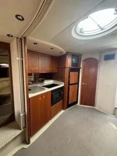 Slide: The Image of 2001 Cruisers Yachts 3870 Express interior kitchen with wood cabinetry and skylight. - 8