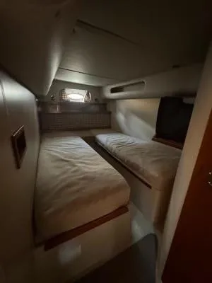 Slide: The Image of 2001 Cruisers Yachts 3870 Express cabin with twin beds and small window. - 13