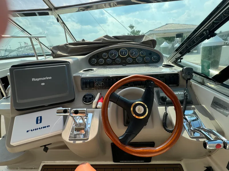 Slide: The Image of Helm of 2001 Cruisers Yachts 3870 Express with Raymarine navigation system and wooden steering wheel. - 3