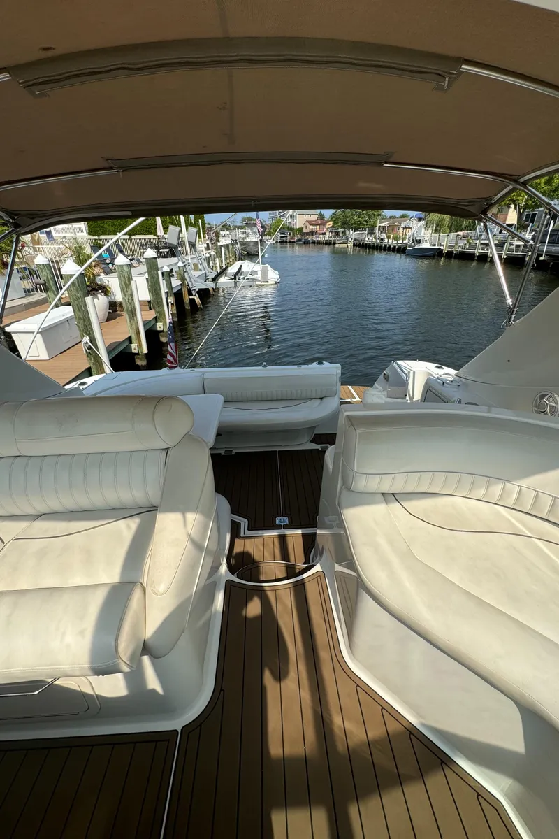 Slide: The Image of 2001 Cruisers Yachts 3870 Express interior with plush seating and waterfront view. - 5