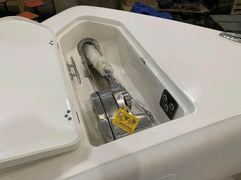 Slide: The Image of 2025 Key West 291FS boat anchor compartment with warning label and controls. - 14