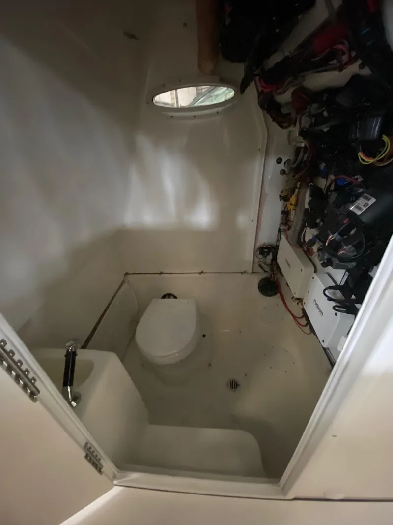 Slide: The Image of Interior of 2025 Key West 291FS boat with compact bathroom and equipment storage. - 15