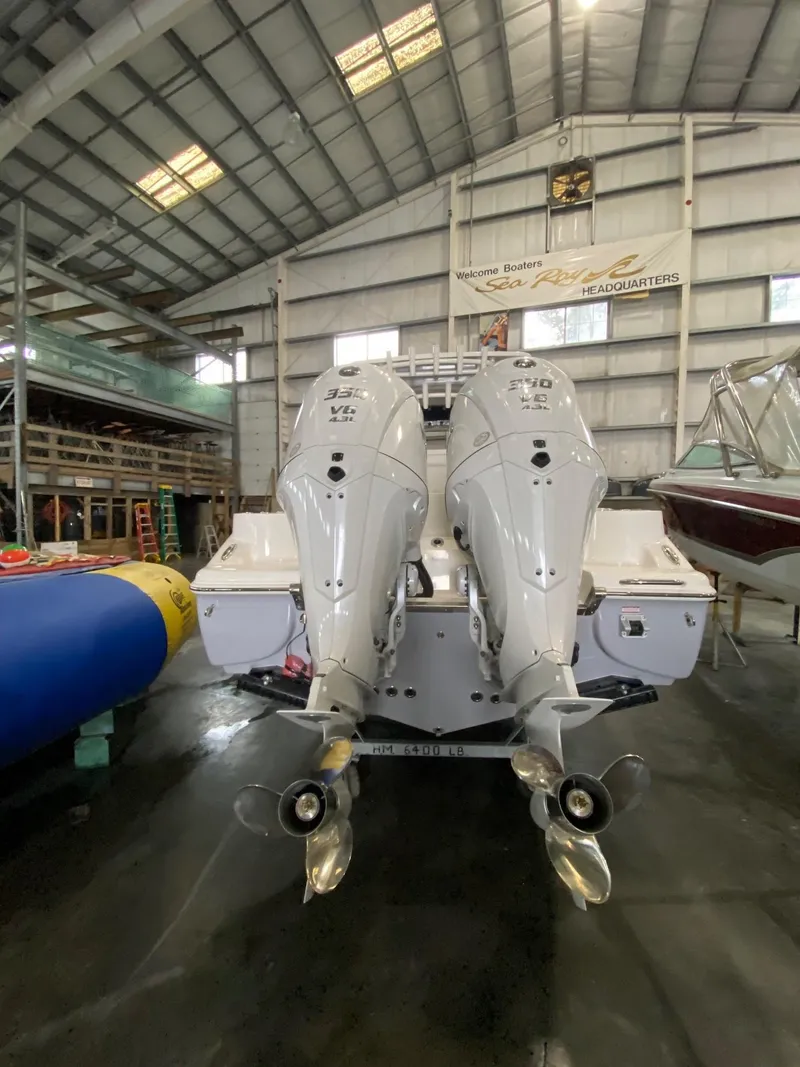 Slide: The Image of 2025 Key West 291FS boat with twin outboard engines in a storage facility. - 2