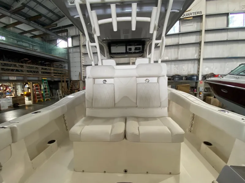 Slide: The Image of 2025 Key West 291FS boat interior with white seating in a warehouse setting. - 7