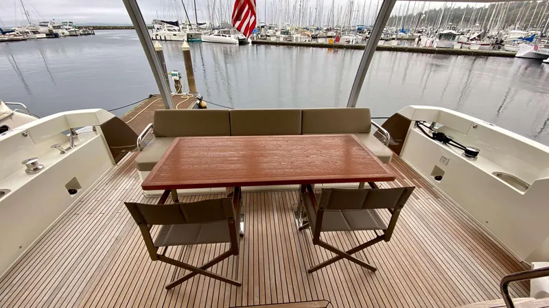 Slide: The Image of Prestige 750 yacht deck with wooden table and chairs, marina view, 2016 model. - 14