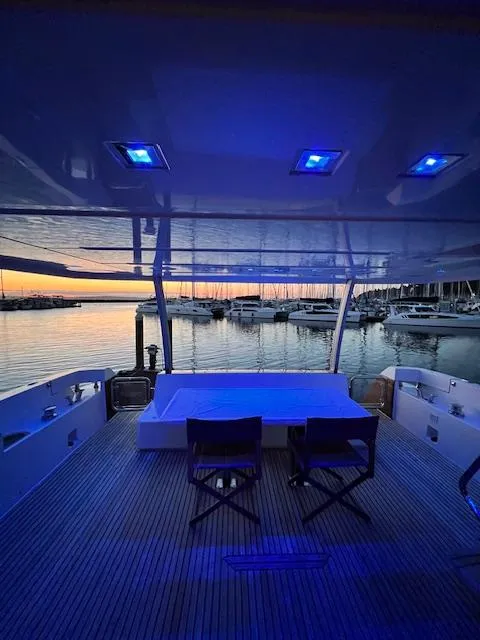 Slide: The Image of Prestige 750 yacht interior with blue lighting, overlooking marina at sunset, 2016 model. - 6
