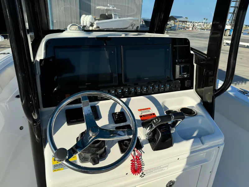 Slide: The Image of 2020 Sea Hunt Gamefish 25 boat dashboard with steering wheel and dual screens. - 12