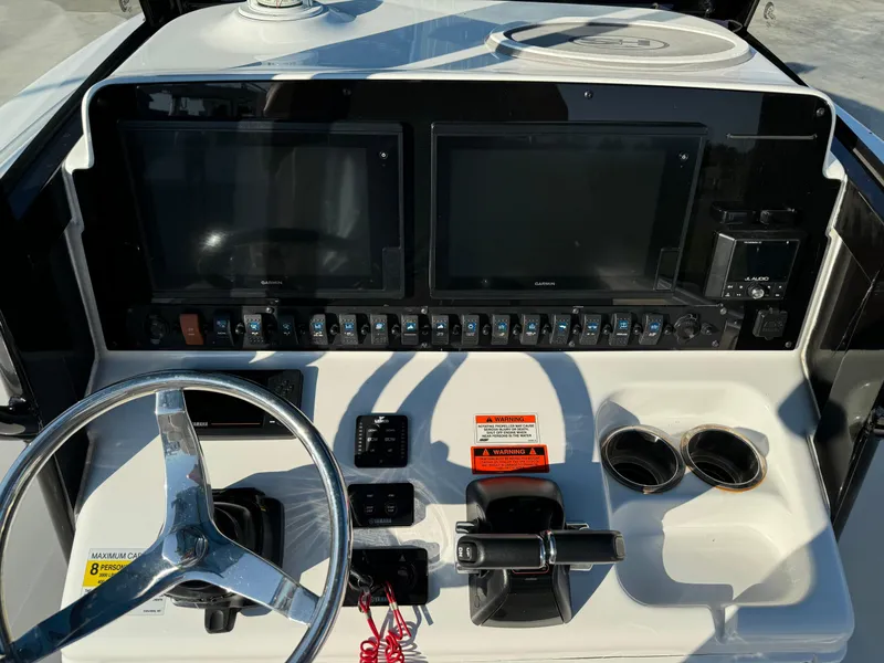 Slide: The Image of 2020 Sea Hunt Gamefish 25 dashboard with dual screens and steering wheel. - 16