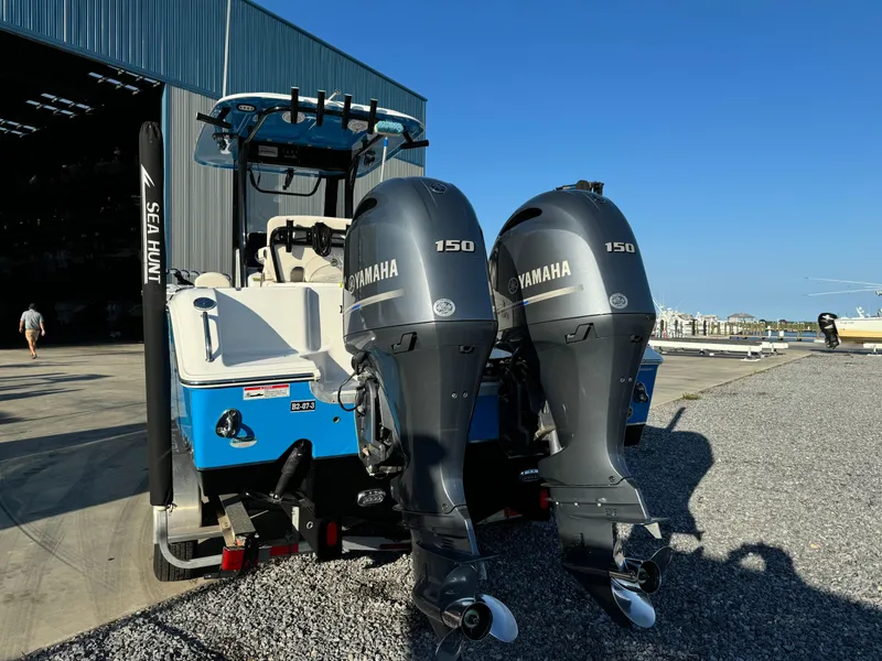Slide: The Image of 2020 Sea Hunt Gamefish 25 with twin Yamaha 150 engines, parked near a marina. - 4