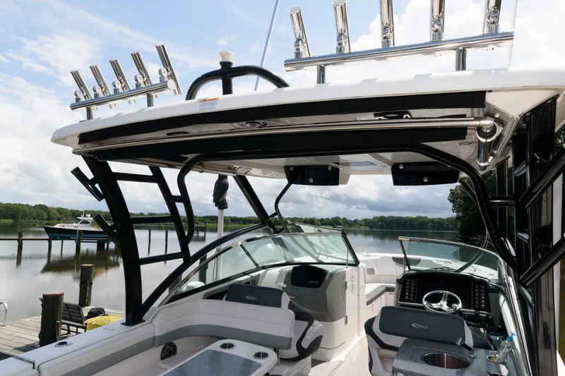 Slide: The Image of 2020 Robalo R317 Dual Console boat interior with fishing rod holders, docked by a serene lake. - 16