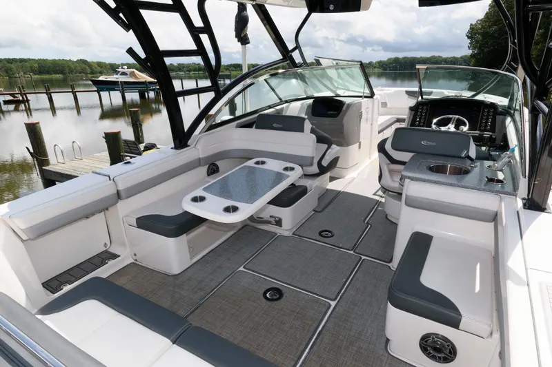 Slide: The Image of 2020 Robalo R317 Dual Console boat interior with seating and table, docked by a serene lake. - 4