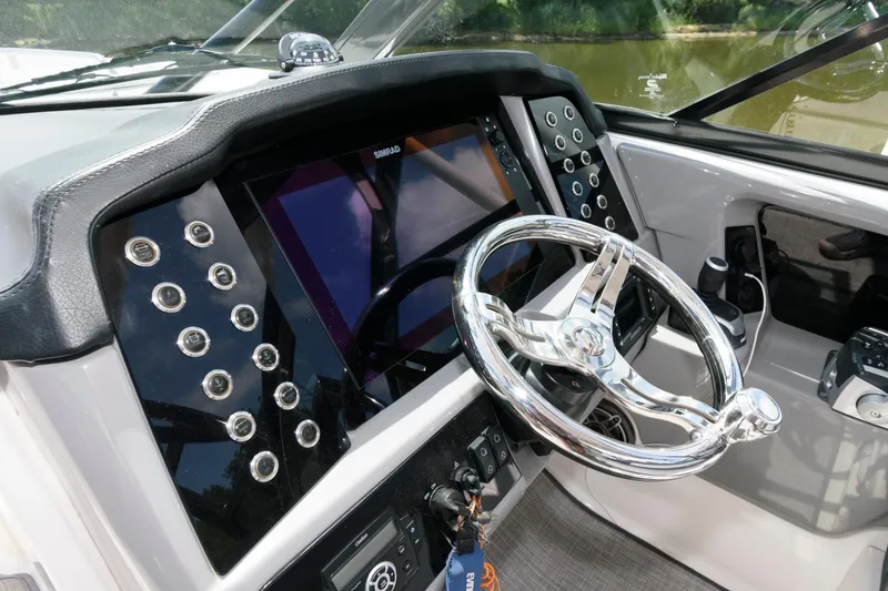 Slide: The Image of 2020 Robalo R317 Dual Console boat dashboard with modern controls and steering wheel. - 6