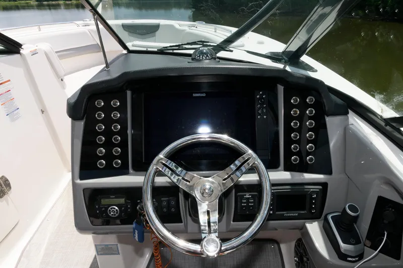 Slide: The Image of 2020 Robalo R317 Dual Console boat dashboard with steering wheel and control panel. - 7