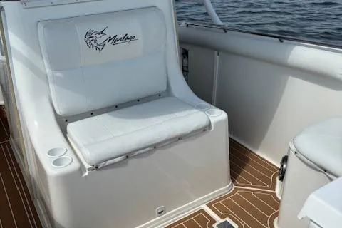 Slide: The Image of 2004 Marlago FS35 boat interior with cushioned seating and wooden flooring. - 10