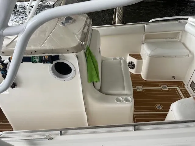 Slide: The Image of 2004 Marlago FS35 boat interior with white seating and wood-patterned flooring. - 11