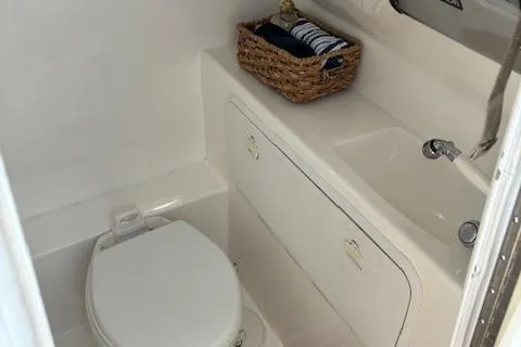 Slide: The Image of 2004 Marlago FS35 boat bathroom with toilet, sink, and storage basket. - 12