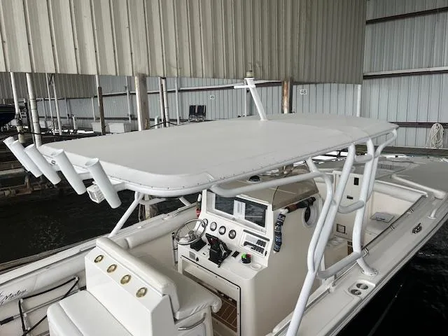 Slide: The Image of 2004 Marlago FS35 boat with T-top and console in a covered dock. - 14