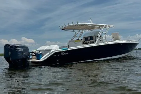 Slide: The Image of 2004 Marlago FS35 boat on water with Yamaha engines, under a cloudy sky. - 2