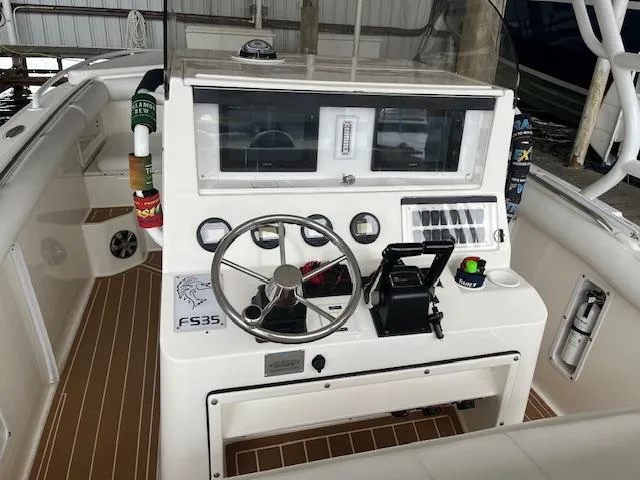 Slide: The Image of 2004 Marlago FS35 boat dashboard with steering wheel and control panel. - 6