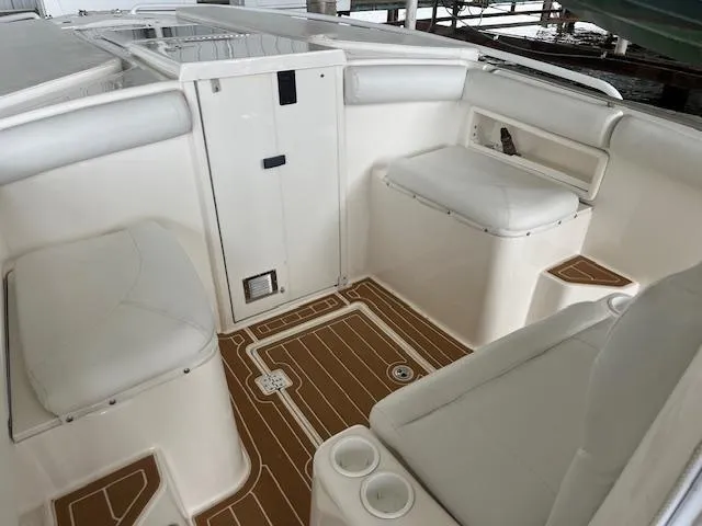 Slide: The Image of 2004 Marlago FS35 boat interior with white seating and wood-patterned flooring. - 9