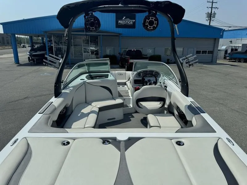 Slide: The Image of 2012 Century Avalanche boat interior with seating and dashboard, parked outside a blue building. - 8