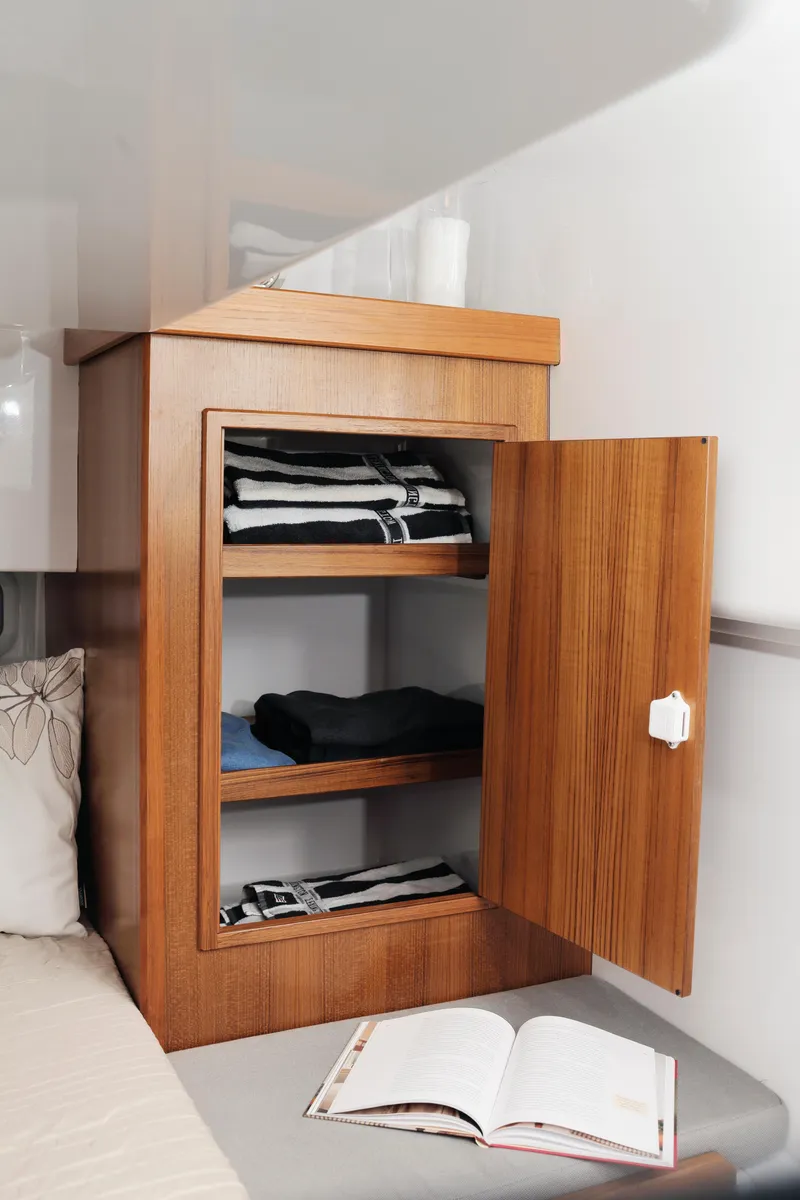 Slide: The Image of Wooden cabinet with open door, shelves, and folded clothes in a 2024 Sargo 31 boat. - 10