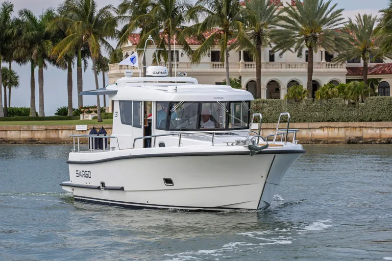 Slide: The Image of 2024 Sargo 31 boat cruising near palm trees and luxury villa. - 17